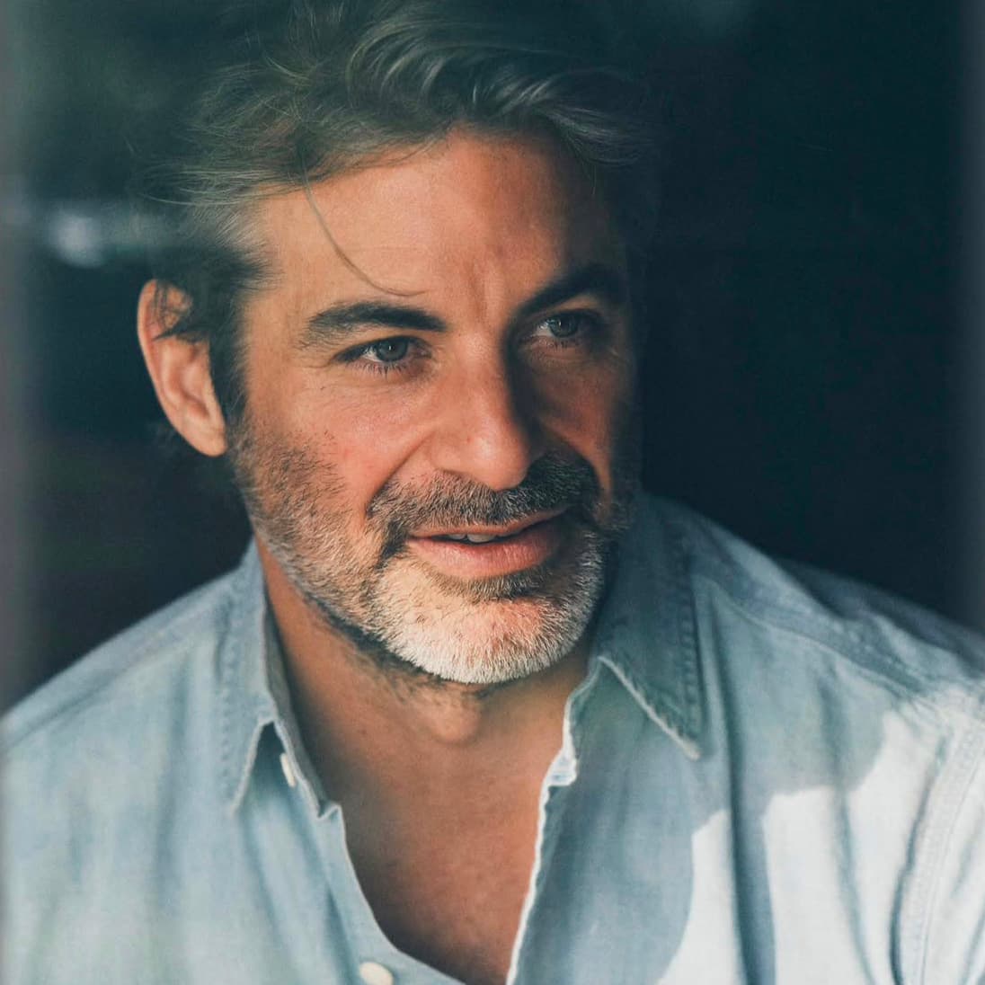 Jim Curtis in a pale blue shirt, close portrait in soft daylight